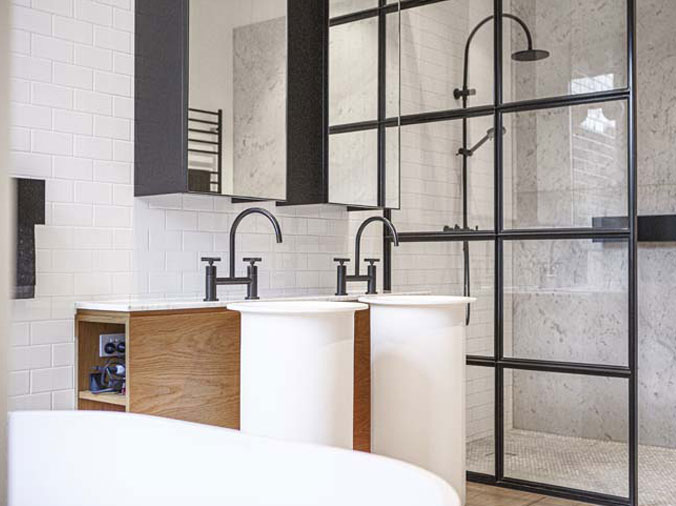Bathroom with black two-know sink faucert and glass shower encolsure