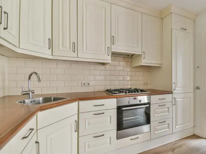 Kitchen with white cabinets and brown wood countertops