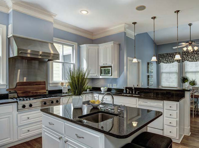 Kitchen with black stoine countertops and white cabinets