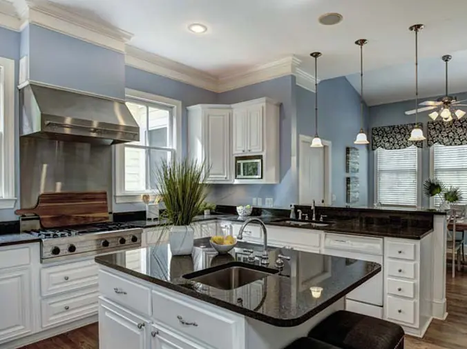 Kitchen with black stoine countertops and white cabinets